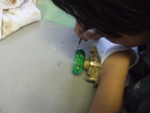 特殊な筆で岩絵具を使った彩色